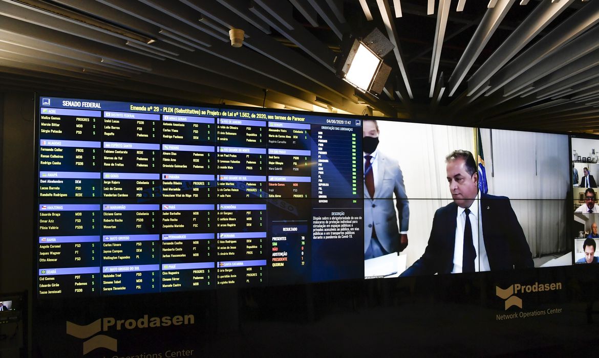 Sessão Deliberativa Remota (SDR) do Senado Federal realizada a partir da sala de controle da Secretaria de Tecnologia da Informação (Prodasen). Ordem do dia.

Na pauta três projetos relacionados ao enfrentamento à pandemia da covid-19: o PL 1.562/2020, que estabelece a obrigatoriedade do uso das máscaras de proteção em locais públicos e privados enquanto durar a pandemia da covid-19; o PL 1.075/2020, que prevê uma série de suportes financeiros aos trabalhadores do setor cultural, que estão parados e sem fontes de renda devido à suspensão das atividades artísticas no país; e por fim, o PL 1.888/2020 que prevê o apoio financeiro aos asilos e instituições de permanência de idosos durante a pandemia. 

Painel eletrônico exibe resultado de votação: Senado aprova o substitutivo ao Projeto de Lei 1.562/2020, que torna obrigatório o uso de máscaras protetoras em locais públicos. A matéria vai à Câmara do Deputados.

2º secretário da Mesa Diretora do Senado Federal, senador Eduardo Gomes (MDB-TO), preside sessão. 

Foto: Leopoldo Silva/Agência Senado